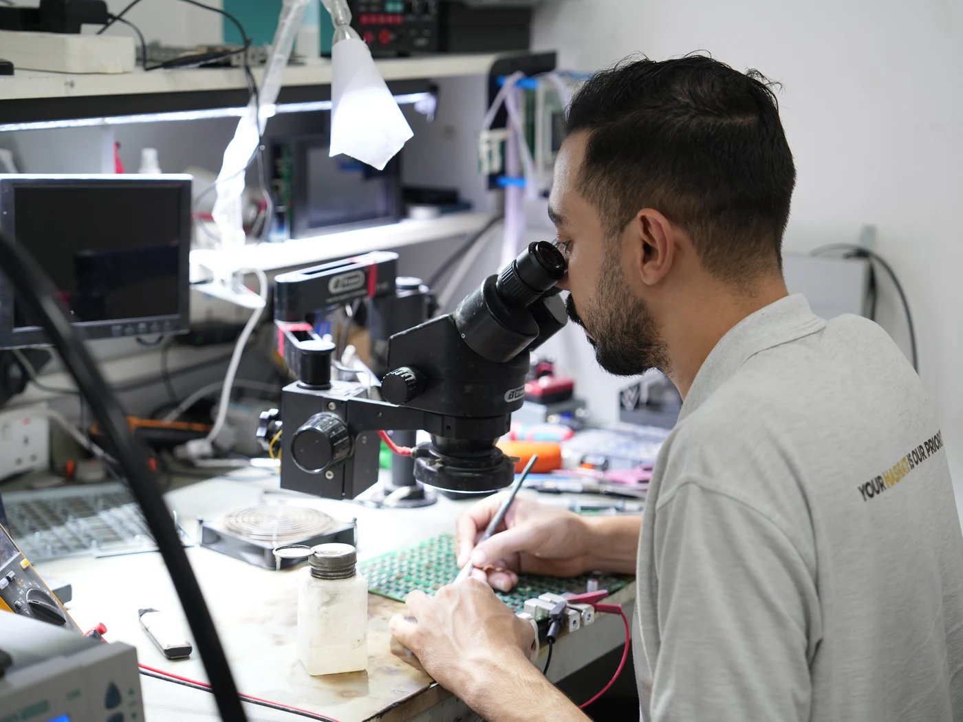 Technician repairing an ASIC miner at the CryptoMiners service bench