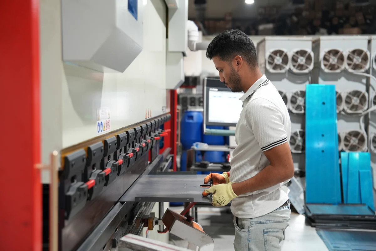 Technician forming a panel on a CNC press brake