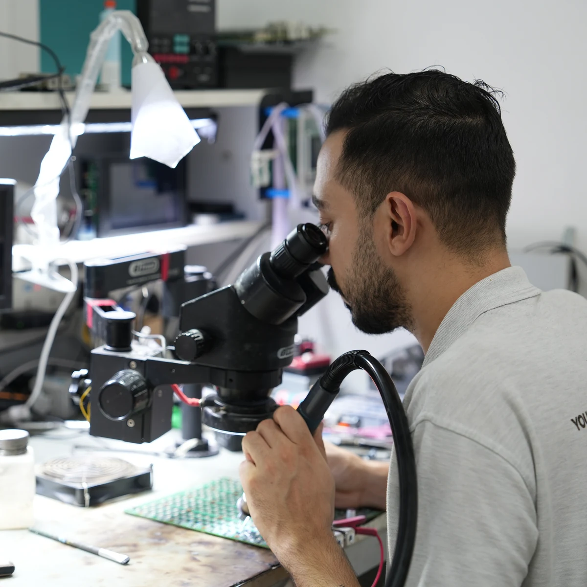 CryptoMiners technician at the board-level repair bench
